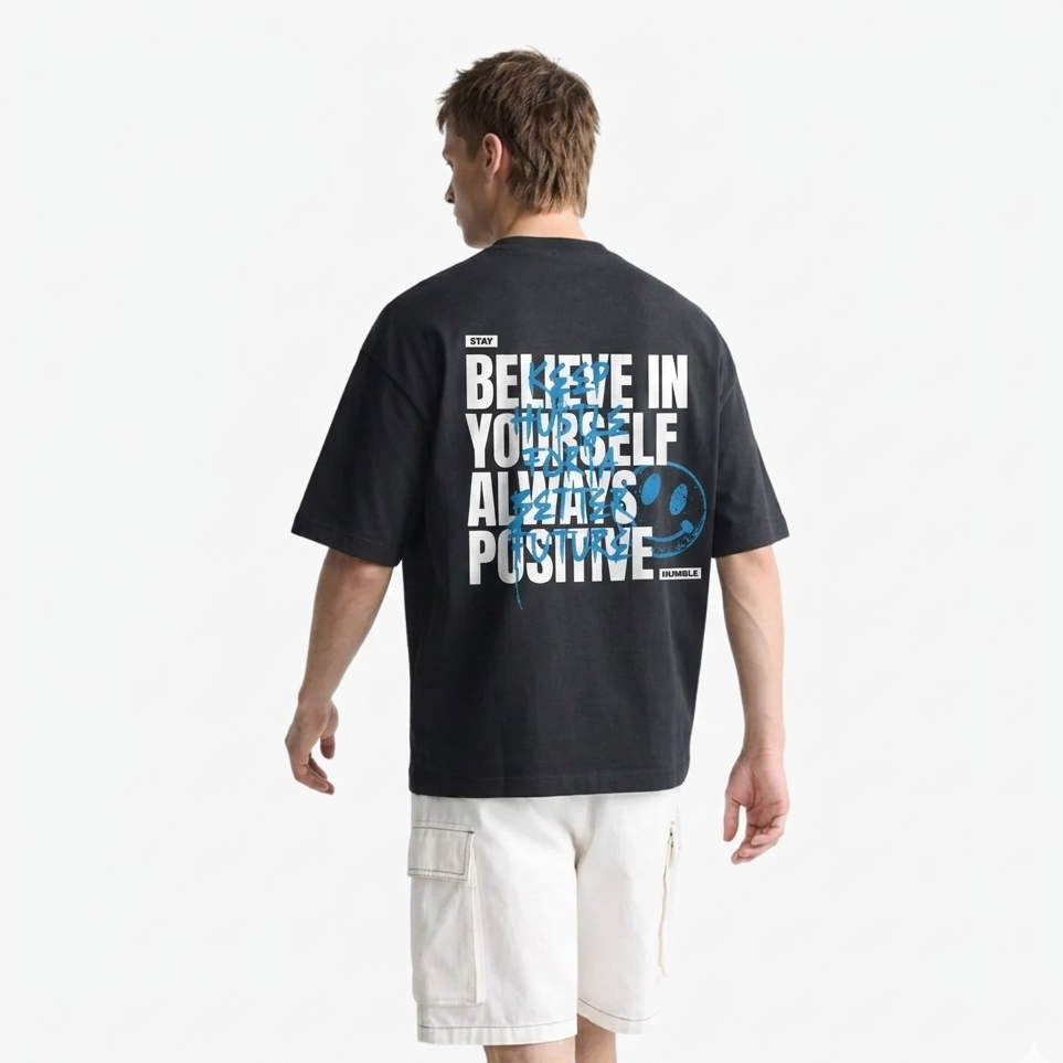 Person wearing a black t-shirt with motivational text on the back, standing against a white background